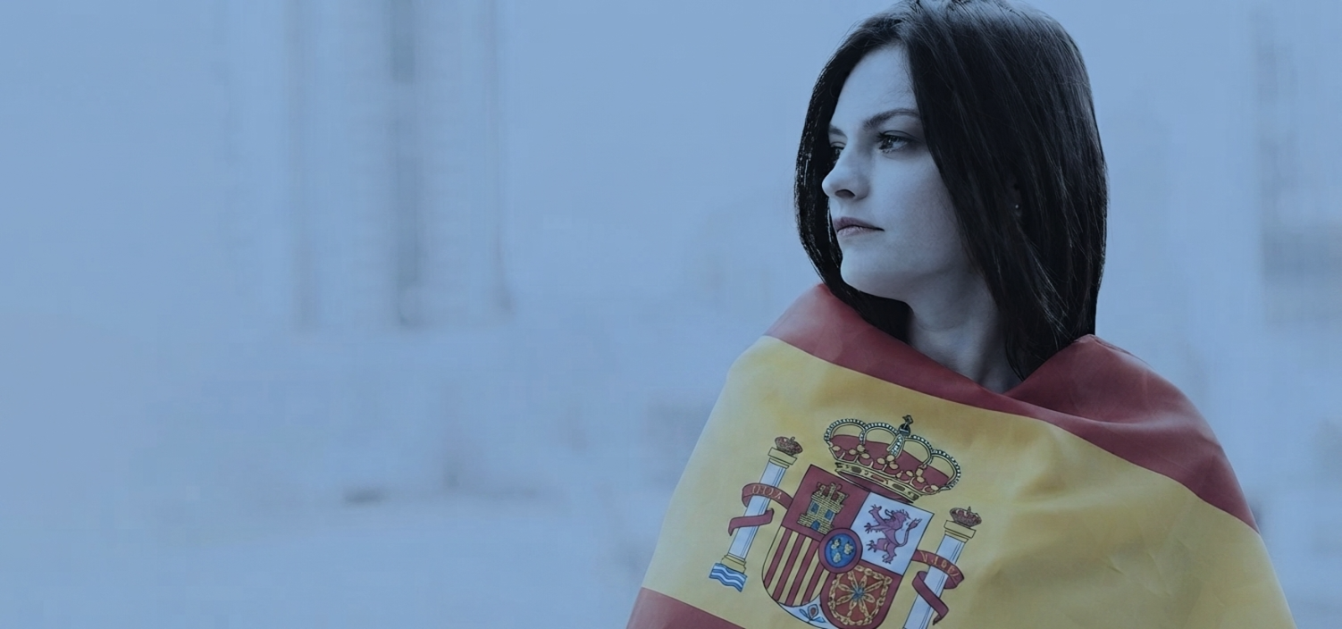 Chica abrigada con bandera españa